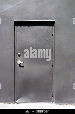 Grey door on grey wall Stock Photo