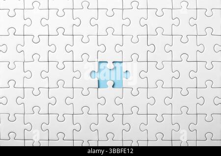 White Puzzle with Single Missing Piece Revealing blue Background Stock Photo