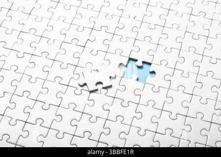 Close-Up of Puzzle Missing a Piece with Bright Blue Background Stock Photo