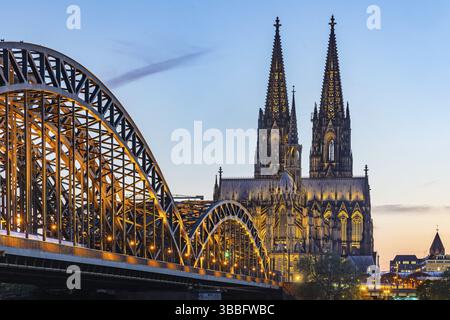 Cologne Cathedral, illuminated in the evening. Hohenzollern Bridge, railway bridge over the Rhine. City view of Cologne, North Rhine-Westphalia, Germa Stock Photo