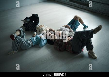 People Lying on Floor Relaxing in Modern Space Stock Photo