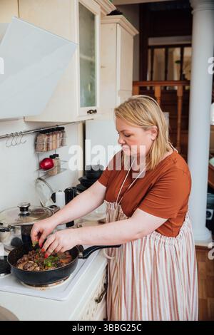 Blonde Cook Housewife Preparing Meals In Kitchen For Lunch Stock Photo