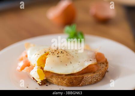 A slice of bread with a cooked egg and lightly salted red fish. Stock Photo