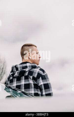 Young man thoughtful standing outdoors cloudy sky Stock Photo