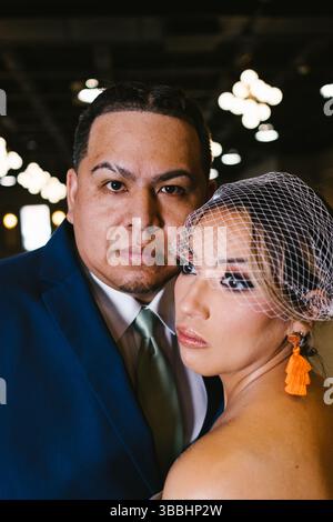 Hispanic Groom and Bride with birdcage veil look serious Stock Photo