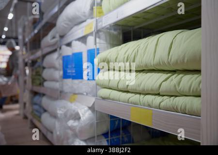 Long row of shelves packed with blankets and pillows in a store Stock Photo
