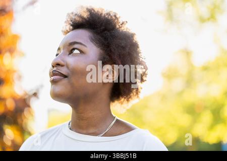 Smiling young woman in the park on a sunny day Stock Photo