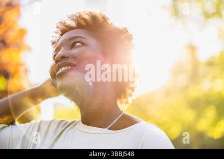 Smiling young woman in the park on a sunny day Stock Photo
