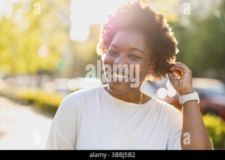 Smiling young woman in the park on a sunny day Stock Photo