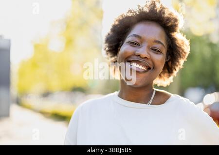 Smiling young woman in the park on a sunny day Stock Photo