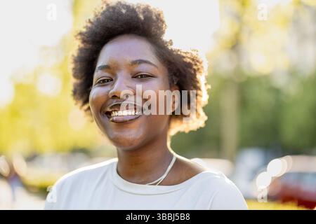 Smiling young woman in the park on a sunny day Stock Photo