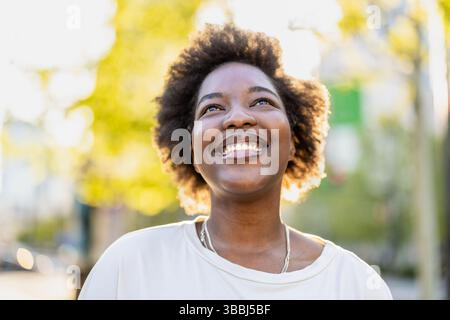 Smiling young woman in the park on a sunny day Stock Photo