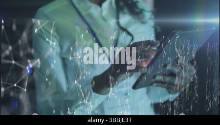 Image of connections over midsection african american man working on tablet in server room Stock Photo