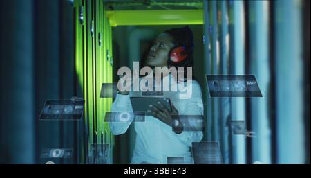 Image of data processing on screens over african american woman working in server room Stock Photo