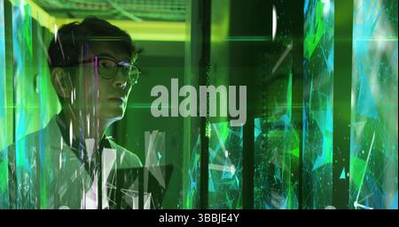 Image of shapes and lines over asian woman working in server room Stock Photo