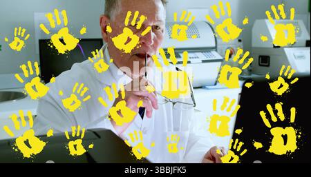Holding eyeglasses and pen, senior man in lab coat reviewing data in lab office, with printers Stock Photo