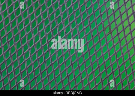 A black metal mesh with green background. Stock Photo