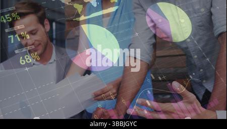 Collaborating professionals reviewing charts and data overlays in office, with laptop smartphone Stock Photo