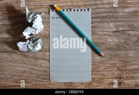 To do list blank note paper and a pencil on wooden background. Crumpled sheet of paper at the side. Work list top view empty note book page on wooden Stock Photo
