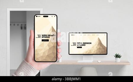 Web design studio concept with app and website shown on smartphone and computer in office setting Stock Photo