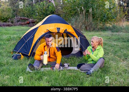 Couple having hot drinks in nature Stock Photo