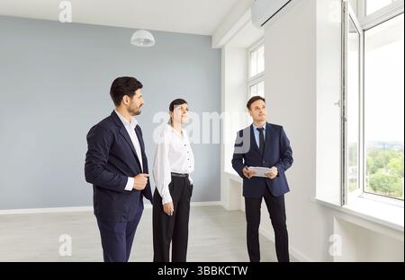 Real estate agent shows people an empty house Stock Photo