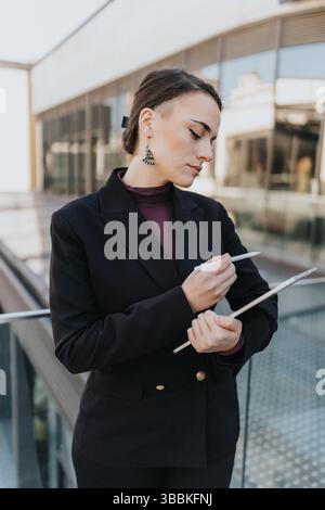 Confident businesswoman analyzing documents outdoors on a modern office terrace Stock Photo