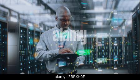 Futuristic Big Data Center with VFX: African American Administrator Using Digital Tablet. Animated Diagrams of Internet Traffic on Servers. Information Technology, Digitalization Concept. Medium Shot. Stock Photo