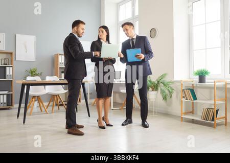 Team of business people with laptop computer working together and discussing something Stock Photo