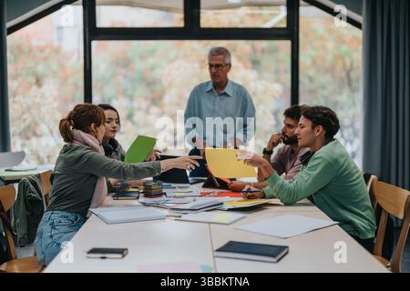 University students collaborating on a project with senior professor guidance Stock Photo