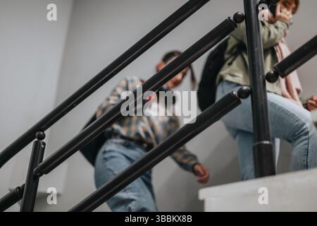 Two students walking upstairs heading to class at school Stock Photo