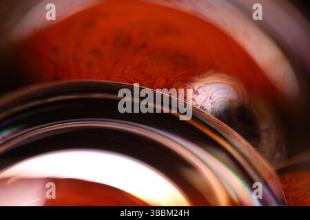 Red fluid reflections on black background, liquid surface abstraction, colour edge, deep dark backgrounds, geometric water shapes, connected lines Stock Photo