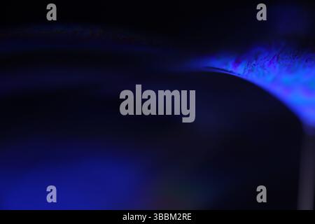Deep purple liquid surface on black background, oil stains movement, bright chemistry, deep space background, connection lines Stock Photo