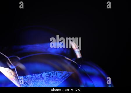 Deep purple liquid surface on black background, oil stains movement, bright chemistry, deep space background, connection lines Stock Photo