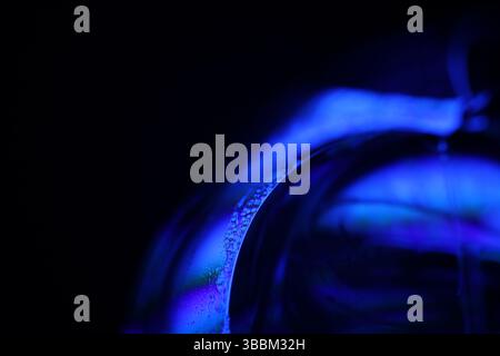 Deep purple liquid surface on black background, oil stains movement, bright chemistry, deep space background, connection lines Stock Photo