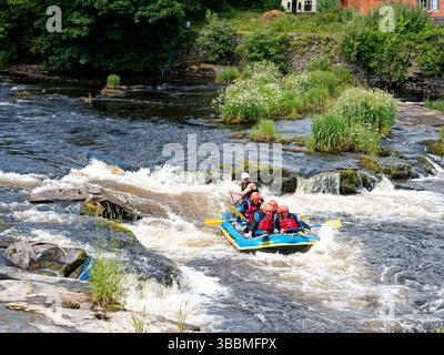 White water rafting on the River Dee at Llangollen with an inflatable raft shooting the rapids. Stock Photo