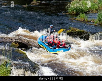 White water rafting on the River Dee at Llangollen with an inflatable raft shooting the rapids. Stock Photo