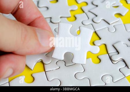 Close up of hand place missing jigsaw puzzle representing problem solving skill. Stock Photo