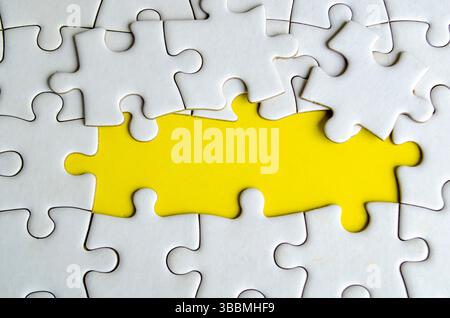 Symbol of partnership and unity shown through connected puzzle pieces on a vivid yellow background. Stock Photo