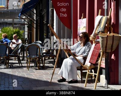 Woman painting street artist at work in Honfleur, Normandy, France. Stock Photo