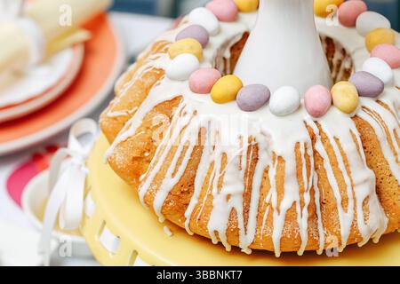 Traditional Easter bundt cake. Icing drips on top. Decorated with sugar eggs. Festive spring dessert. Sweet homemade pastry. Holiday celebration treat Stock Photo
