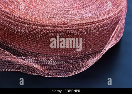 Copper mesh, twisted into a roll, close up. Twisted copper mesh. Stock Photo