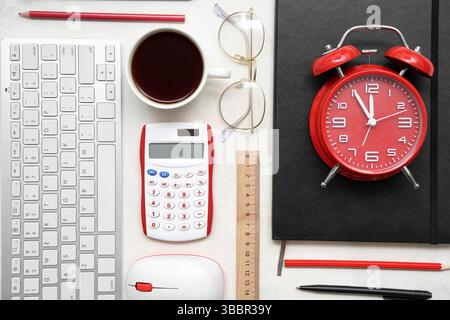 Composition with different stationery, modern gadgets, cup of coffee and alarm clock on light background Stock Photo