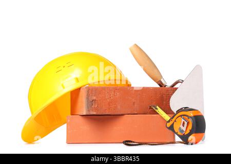 Hardhat, bricks and construction tools on white background Stock Photo