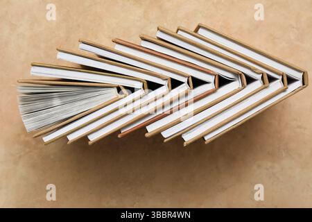Many different half open books on beige grunge background Stock Photo