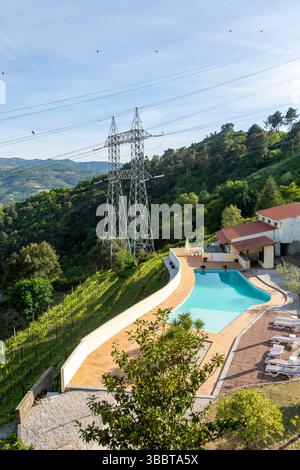 Electricity pylons crossing countryside over swimming pool, Tresouras ...
