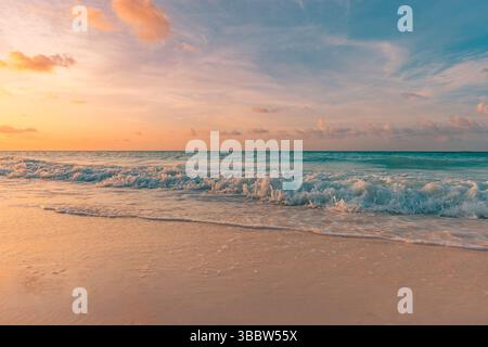 Serene views. Gorgeous sunset beach with calm waves and colorful sky, soft clouds over tranquil ocean seascape, peaceful tropical evening nature scene Stock Photo