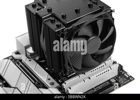 CPU air cooler with a large heatsink and fan installed on a modern computer motherboard. Stock Photo