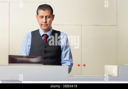 Hotel, happy and portrait of man at reception for welcome, travel booking or luxury accommodation. Working, face and receptionist at front desk for ch Stock Photo