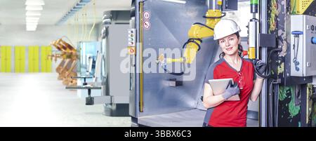 A young female technician while machine constructing in a manufacturing plant Stock Photo